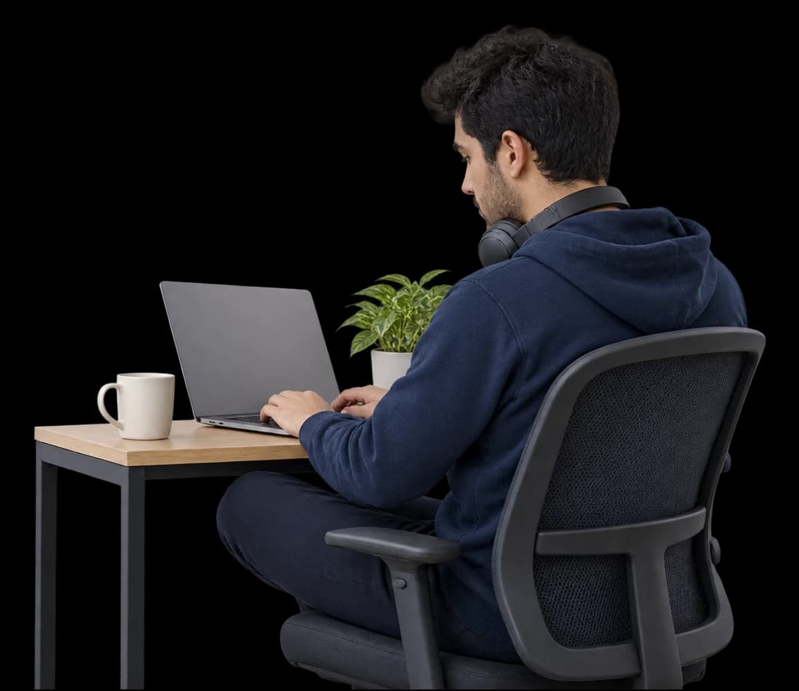 A software engineer works at a laptop at a compact desk.